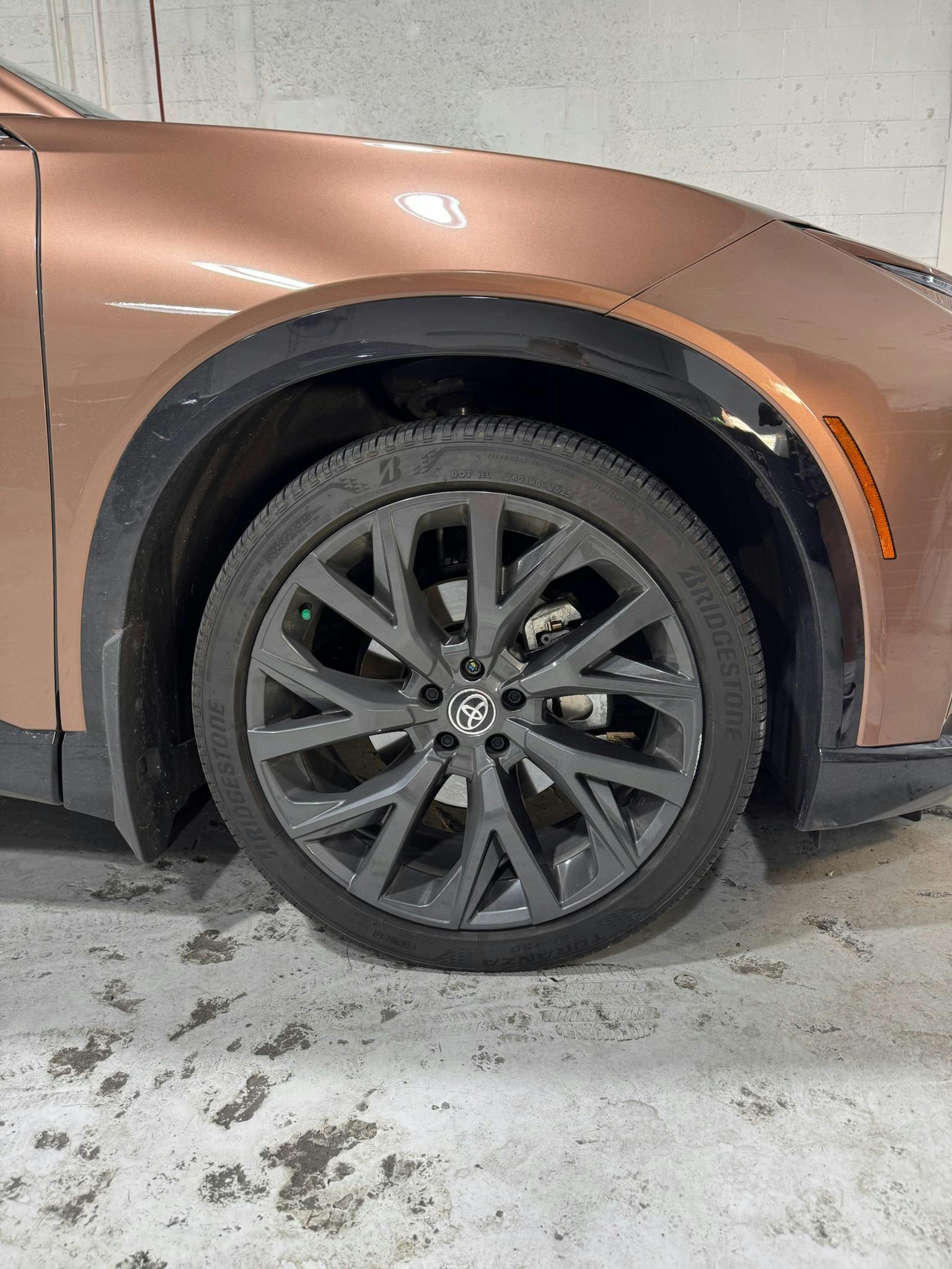 Toyota wheel with freshly painted green brake caliper visible behind spokes