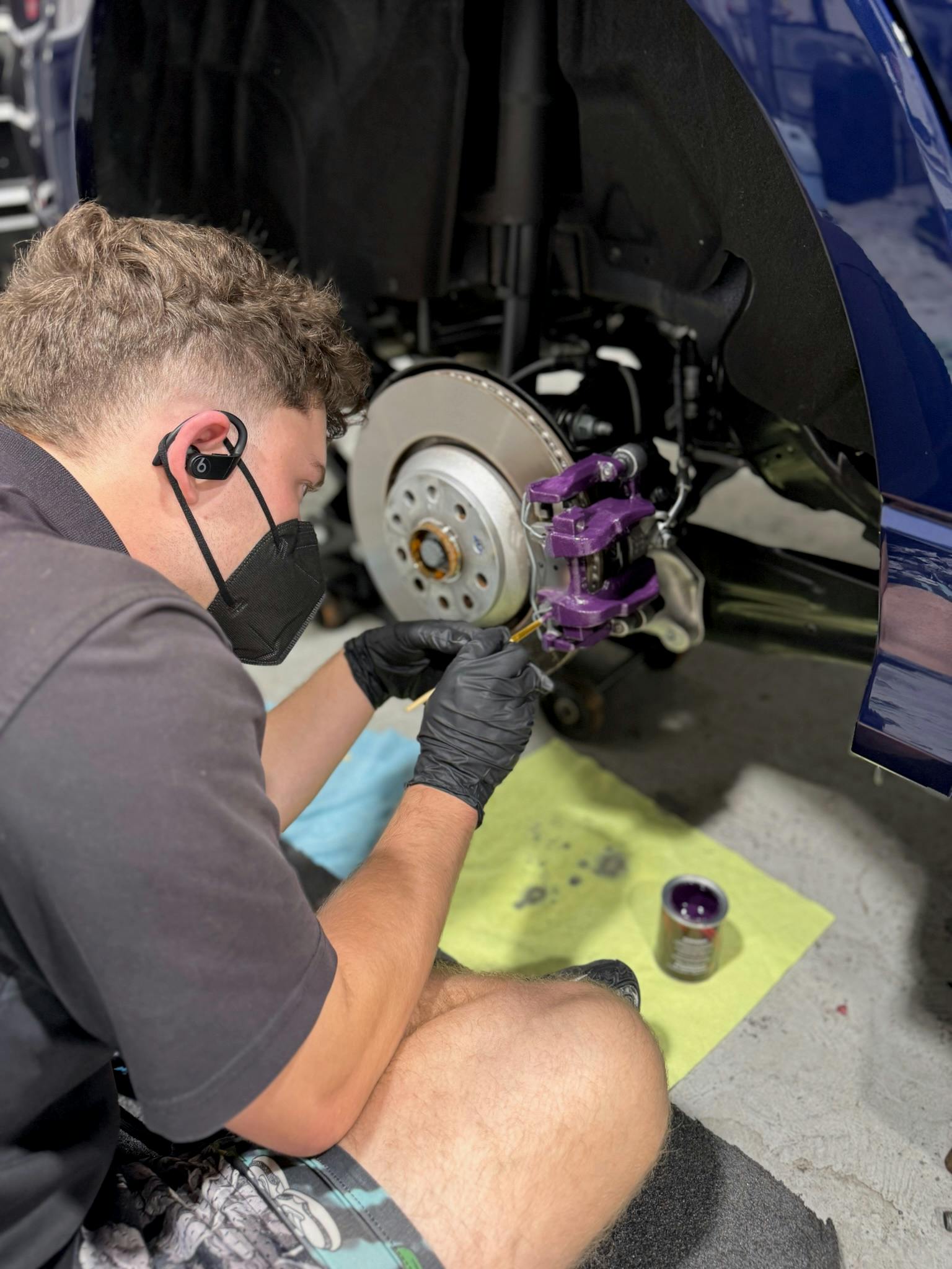 Finished purple brake caliper next to clean brake rotor after painting