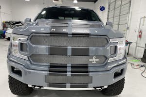 Close-up view of the front end of a silver Shelby F-150 truck