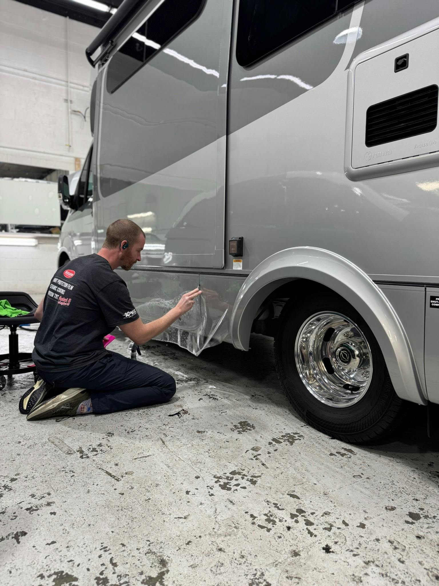 XPEL paint protection film being applied to the front cap of an RV