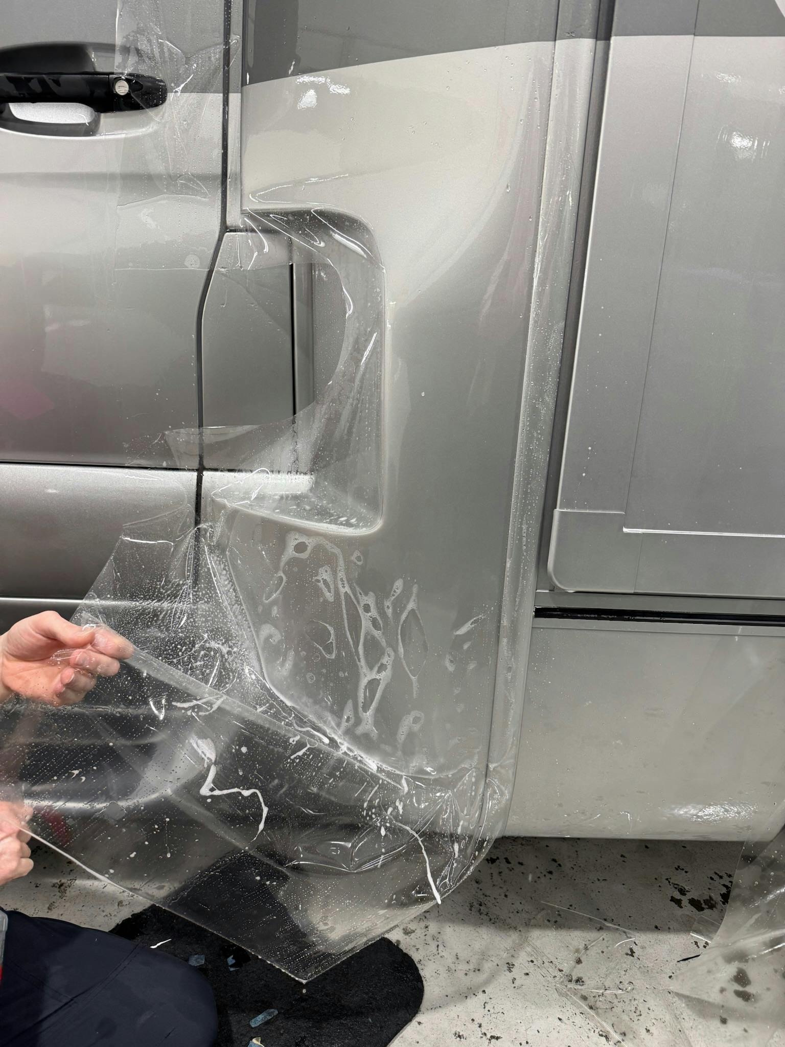 Paint protection film conforming around an RV door handle and body seam