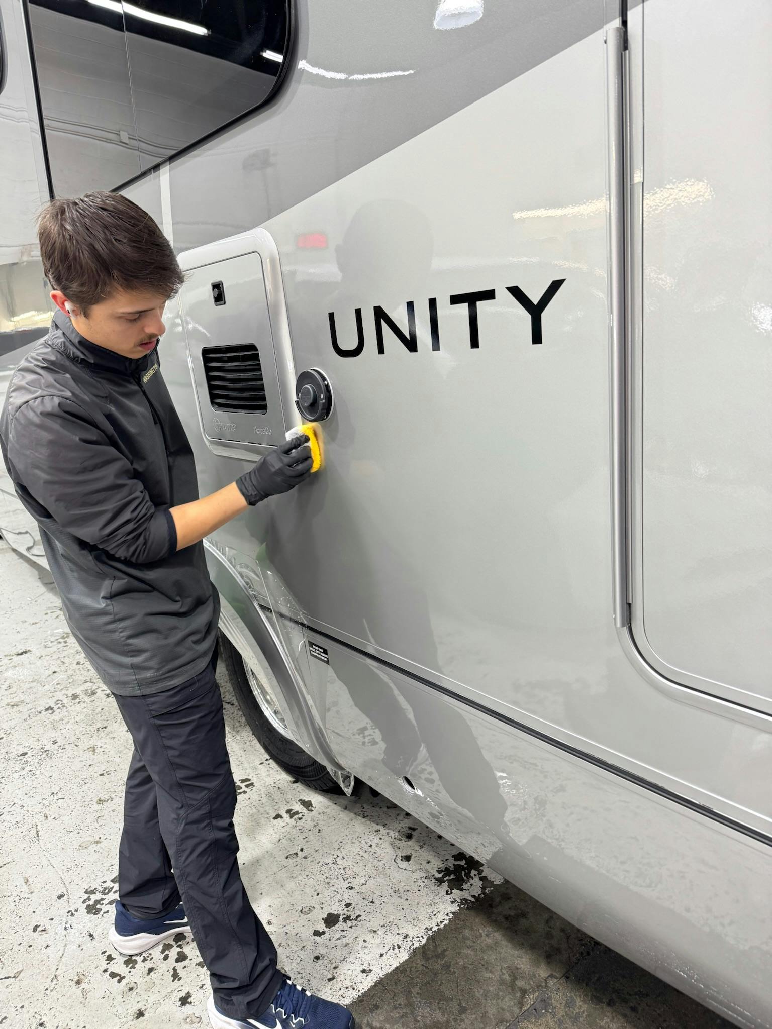 Detailer buffing the protected side panel of a Leisure Travel Vans Unity
