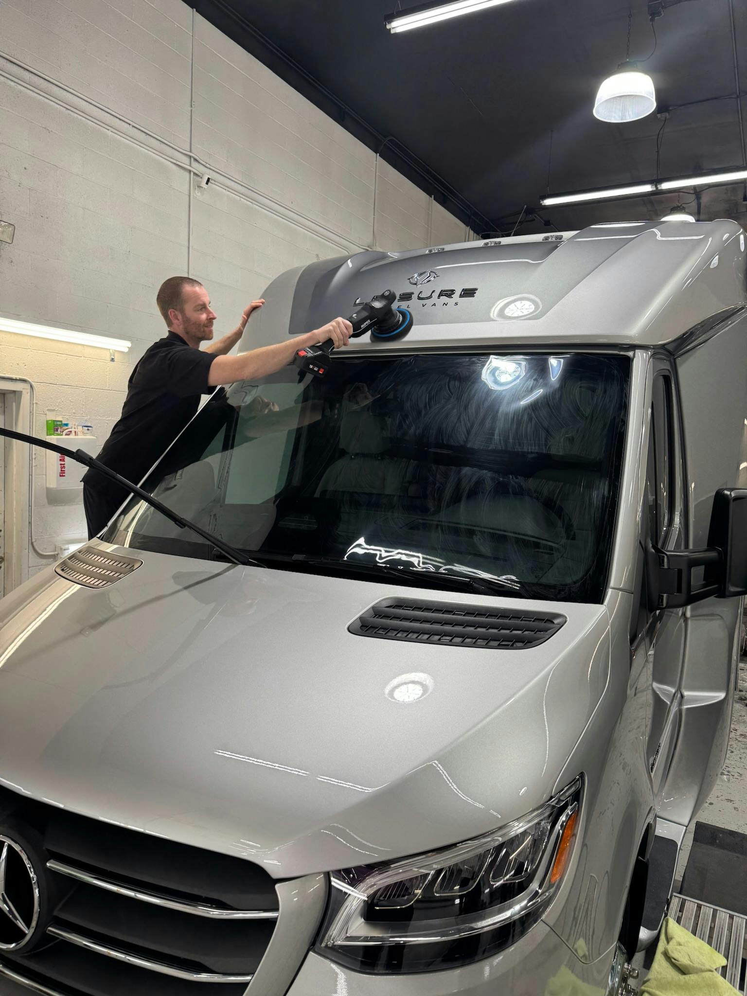 Polishing the front cap of a Mercedes Sprinter RV before film