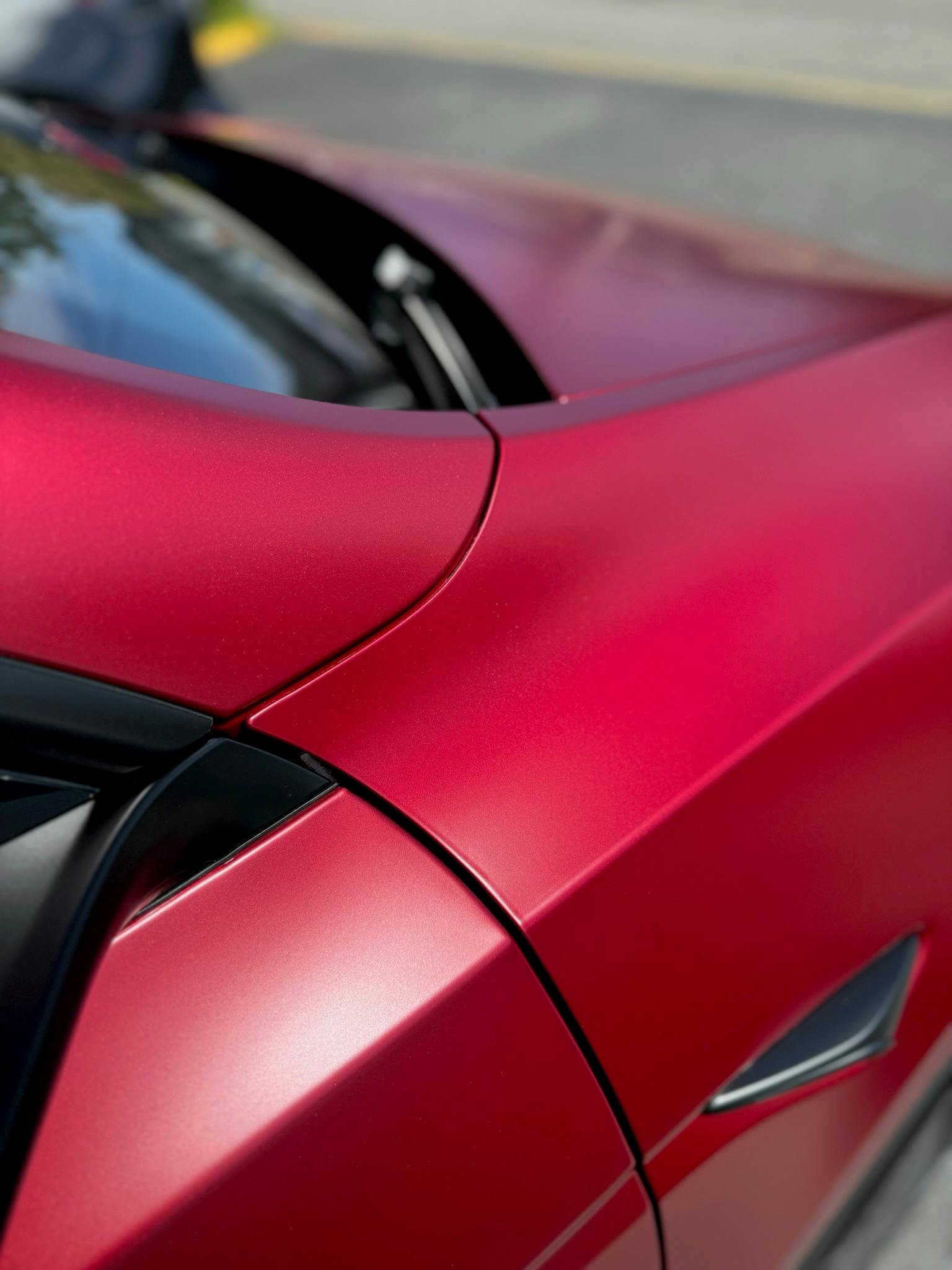 Close-up of XPEL STEALTH satin PPF on a red Tesla Model Y