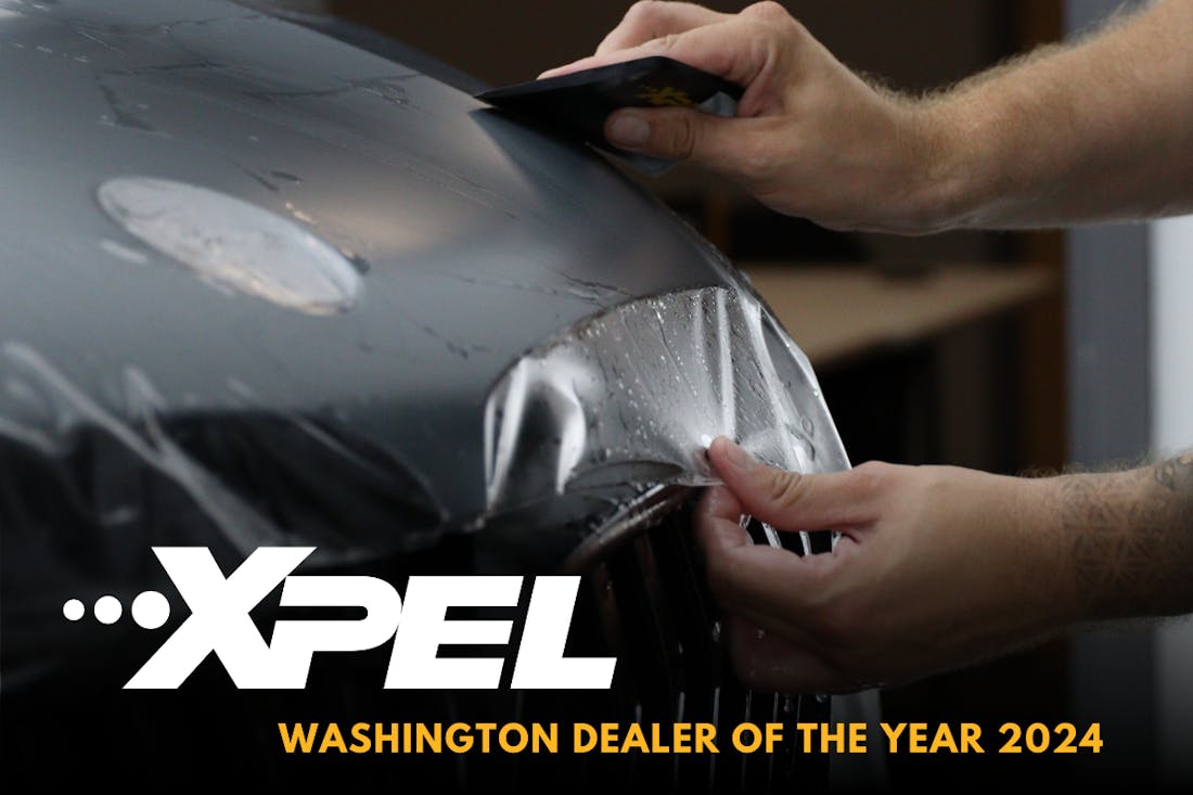 Tech Applying PPF Film as background for text: Xpel Washington Dealer of the Year 2024